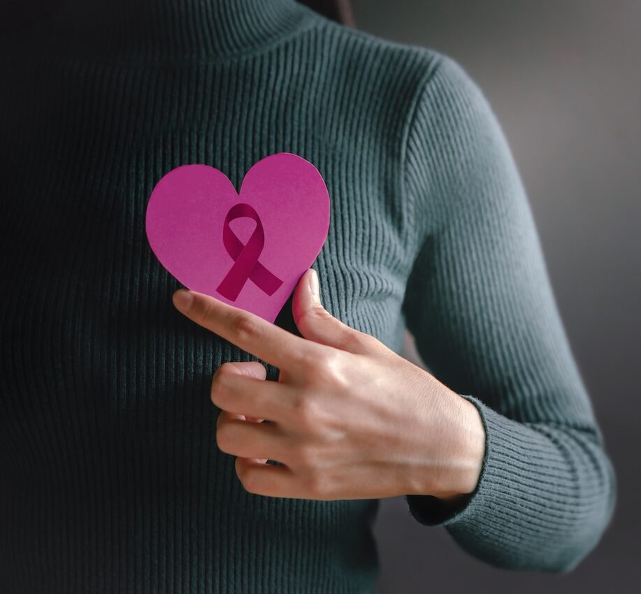 Vrouw houdt Pink Ribbon hart vast